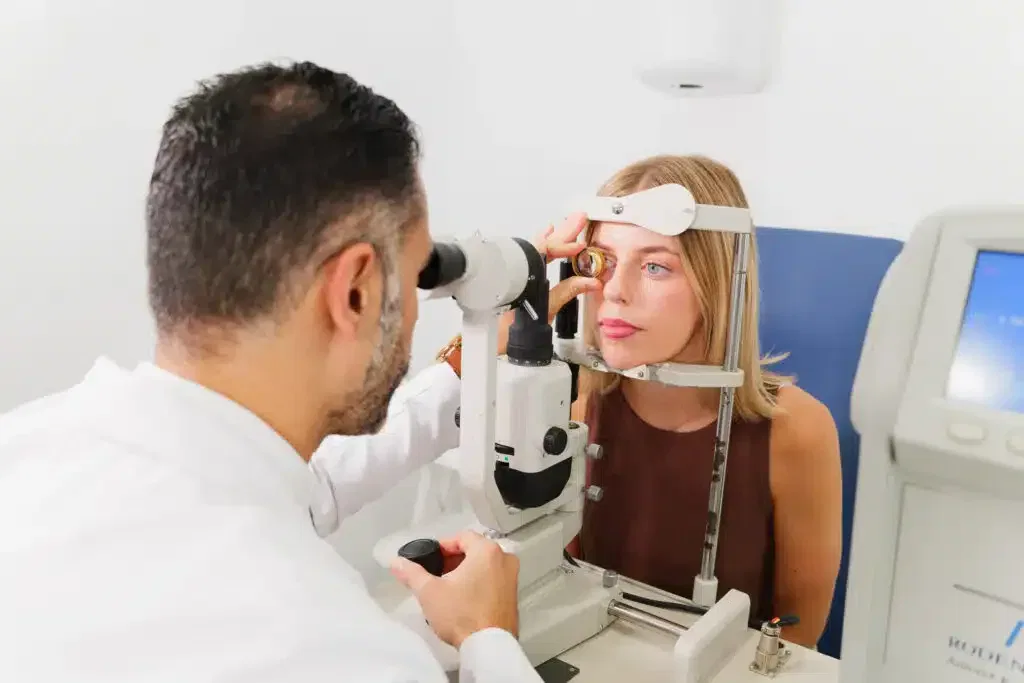 Examen ocular en consulta médica, donde un optometrista realiza una evaluación de la vista a una paciente usando un equipo especializado.