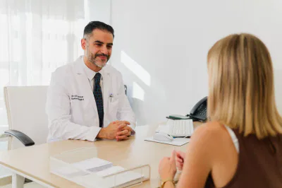 Oftalmólogo en Marbella 15 Médico en consulta con paciente en un entorno profesional, discutiendo opciones de tratamiento.